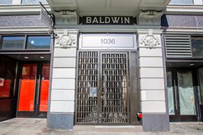 San Francisco apartment for rent - The front of a building with a large gate and a sign that reads "BALDWIN 1036".