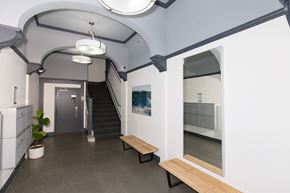 San Francisco apartment for rent - A hallway with a staircase, a plant, and a framed picture on the wall.