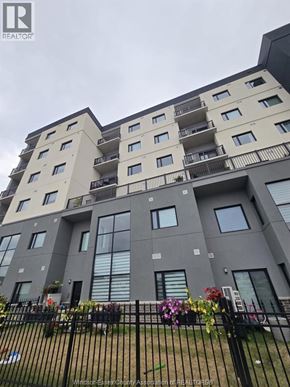 Lasalle condo for rent - A large apartment building with a black fence in front.