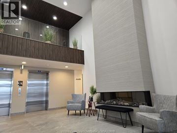 Lasalle condo for rent - A living room with a grey couch and a fireplace.