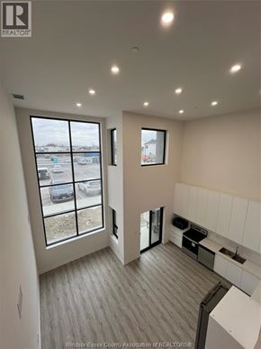 Lasalle condo for rent - A realtor photo of a modern kitchen and living room with a view of a parking lot.