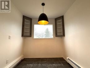 Fort Erie (Crescent Park) apartment for rent - A room with a window and a picture on the wall.