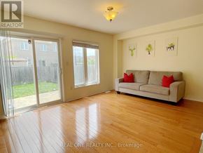 Mississauga (Churchill Meadows) townhouse for rent - A living room with a couch, sliding glass doors, and pictures on the wall.