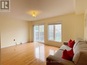 Mississauga (Churchill Meadows) townhouse for rent - A living room with a grey couch and a window.