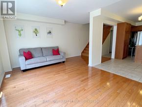 Mississauga (Churchill Meadows) townhouse for rent - A living room with a grey couch and wooden floors.