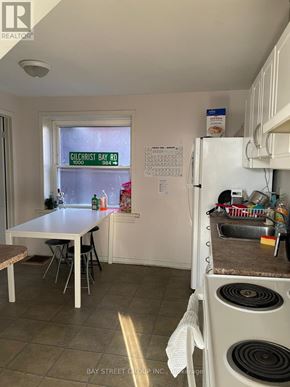 Kingston (Central City East) apartment for rent - A kitchen with a table and chairs and a window with a sign on it.