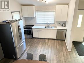Vaughan (Maple) apartment for rent - A kitchen with white cabinets and a black refrigerator.
