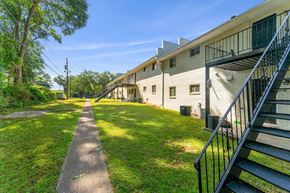 Clarkston apartment for rent - the backyard of a large apartment building with stairs and grass