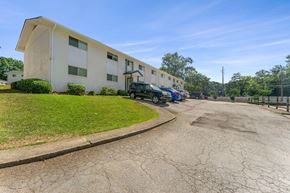 Clarkston apartment for rent - a large white building with cars parked in front of it