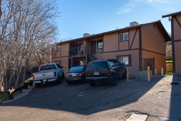 Cottonwood apartment for rent - Two cars are parked in front of a brown building.