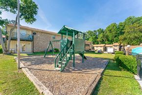 Decatur apartment for rent - a green swing set in a yard in front of a building