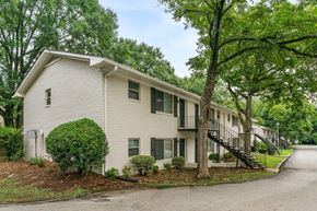 Forest Park apartment for rent - a white building with trees and a street in front of it