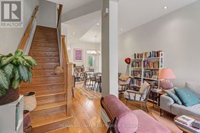 Ottawa apartment for rent - A living room with a couch, chairs, a bookshelf, and a staircase.