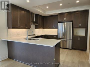London North (North R) condo for rent - A modern kitchen with dark brown cabinets and a stainless steel refrigerator.