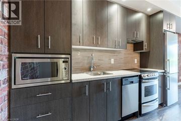 Burlington condo for rent - A modern kitchen with dark wood cabinets and stainless steel appliances.