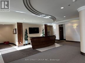 Richmond Hill (Langstaff) condo for rent - A reception area with a brown desk and a flat screen TV mounted on the wall.