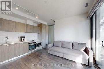 Toronto (Church-Yonge Corridor) condo for rent - A modern kitchen with a couch in the living room.