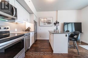 Niagara Falls (Oldfield) condo for rent - A modern kitchen with white cabinets and a black chair.