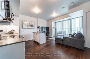 Niagara Falls (Oldfield) condo for rent - A modern kitchen with a grey couch and a wooden floor.