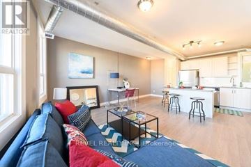 Hamilton (Stipley) apartment for rent - A living room with a blue couch and a kitchen in the background.
