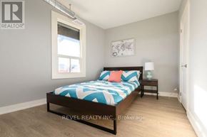 Hamilton (Stipley) apartment for rent - A bedroom with a bed, nightstand, and lamp.