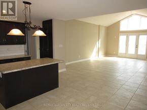 Niagara Falls (Schisler) apartment for rent - A spacious room with a kitchen area and a large window.