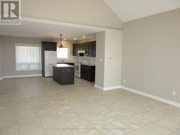 Niagara Falls (Schisler) apartment for rent - A kitchen area with a sink, stove, and refrigerator in a room with tiled flooring.