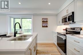 St. Marys townhouse for rent - A modern kitchen with white cabinets and a stainless steel sink.