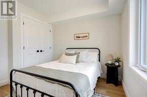 St. Marys townhouse for rent - A bedroom with a bed, nightstand, and a painting on the wall.