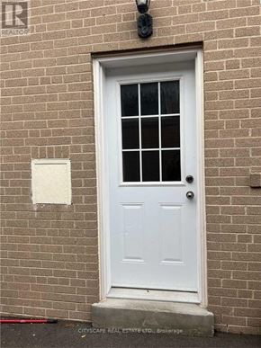 Toronto (Parkwoods-Donalda) apartment for rent - A white door with a glass window is set in a brick wall.