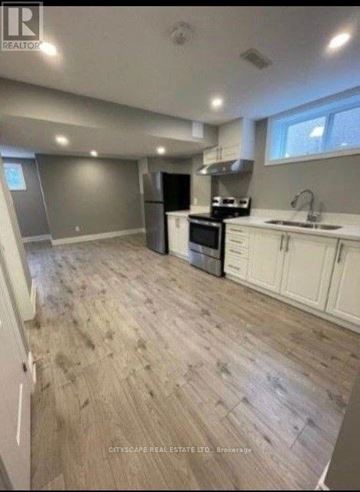 Toronto (Parkwoods-Donalda) apartment for rent - A kitchen with white cabinets and a wooden floor.