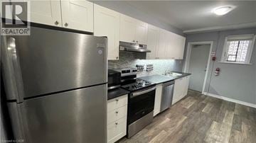 Hamilton apartment for rent - A modern kitchen with a stainless steel refrigerator and wooden flooring.
