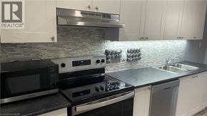 Hamilton apartment for rent - A modern kitchen with a stove top oven and microwave.