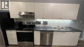 Hamilton apartment for rent - A kitchen with white cabinets and a black countertop.