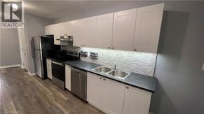 Hamilton apartment for rent - A kitchen with white cabinets and a black countertop.