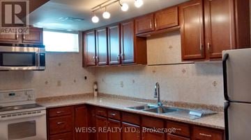 Toronto (Highland Creek) apartment for rent - A kitchen with brown cabinets and a white refrigerator.