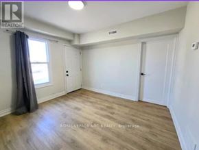 Port Colborne (East Village) fourplex for rent - A room with wooden flooring and white walls, with a window on the left side.