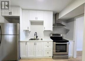Port Colborne (East Village) fourplex for rent - A kitchen with white cabinets and stainless steel appliances.