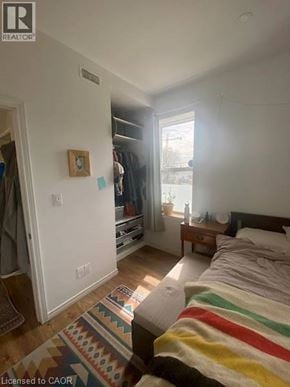 Kitchener apartment for rent - A bedroom with a bed, a rug, and a window.
