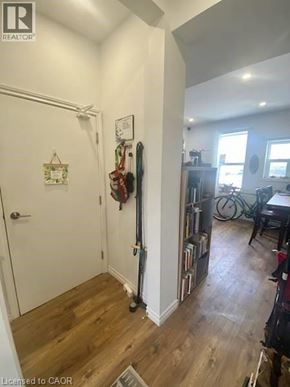 Kitchener apartment for rent - A hallway with a door and a wall with a clock on it.
