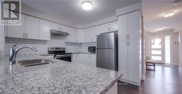Cambridge townhouse for rent - A kitchen with a granite countertop and stainless steel appliances.