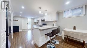 Toronto (West Hill) apartment for rent - A kitchen with white cabinets and a black fridge.