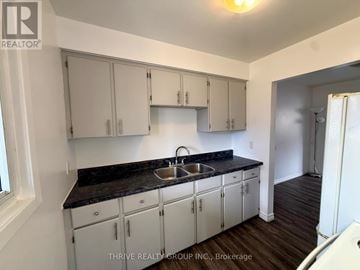 London East (East I) townhouse for rent - A kitchen with white cabinets and a black countertop.