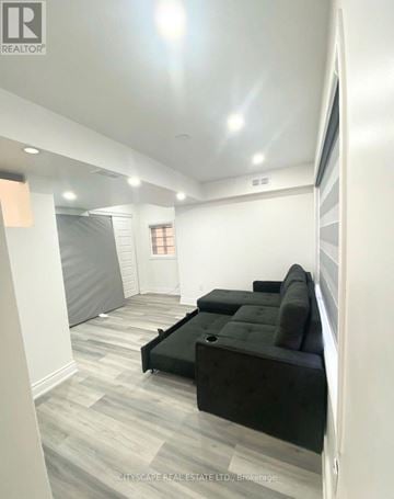 Hamilton (Lakeshore) apartment for rent - A living room with a black couch and grey carpet.