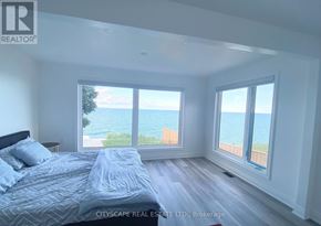 Hamilton (Lakeshore) apartment for rent - A bedroom with a large bed and a view of the ocean through the windows.