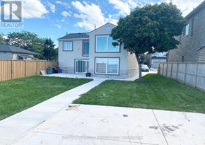 Hamilton (Lakeshore) apartment for rent - A house with a brown fence and a green lawn.