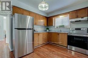 London East (East P) apartment for rent - A kitchen with wooden cabinets and a stainless steel refrigerator.