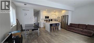 Kitchener apartment for rent - A modern kitchen with white cabinets and a wooden floor.
