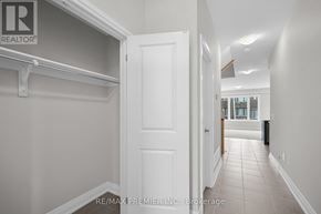 Kawartha Lakes (Lindsay) townhouse for rent - A hallway with a white door and a brokerage sign on the wall.