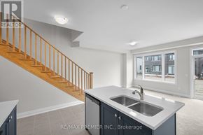 Kawartha Lakes (Lindsay) townhouse for rent - A modern kitchen with a staircase leading to the upper floor.